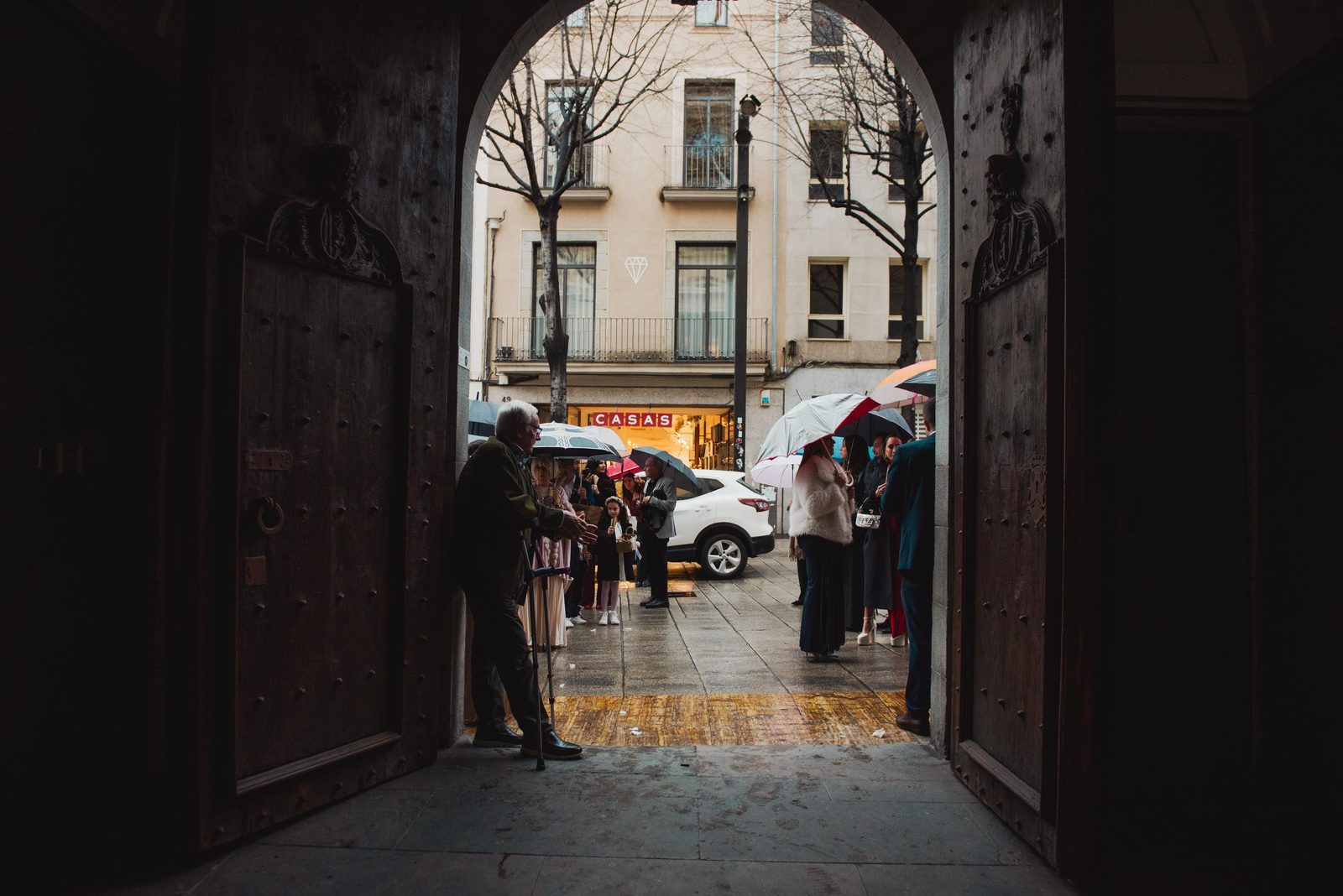 Novios saliendo bajo arco oscuro en una boda en Barcelona